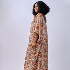 African colorful bubu worn by a woman Flowy Maxi Dress With Short Sleeves For Loungewear, Flowy Short Sleeve Maxi Dress For Loungewear, Casual Multicolor Loose Dress, Oversized V-neck Maxi Dress For Vacation, Bohemian Flowy Beach Dress For Daywear, Casual Flowy Tunic Maxi Dress, Casual Multicolor Boho Print Kaftan, Casual Printed Tunic Maxi Dress, Multicolor Flowy Long Boho Dress