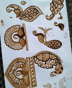 henna tattoos on white paper with gold designs