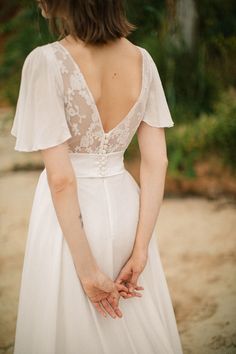 a woman in a white dress holding her hands together