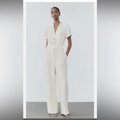 Zara Belted Jumpsuit With Golden Buttons Jumpsuit With Round Collar, V-Neck, And Turned-Up Button Tabbed Short Sleeves. Self Belt With Back Elastic. Front Patch Pockets And Back False Welt Pocket. Wide Leg. Front Zip, Hidden Hooks, And Gold Button Closure. Chic V-neck Jumpsuits And Rompers With Buttons, Chic V-neck Jumpsuits And Rompers With Button Closure, Elegant White V-neck Jumpsuit, Chic Short Sleeve Workwear Pantsuit, Chic Short Sleeve Pantsuit For Work, Summer Pantsuit With Buttons, White Summer Jumpsuits And Rompers For Work, Summer Workwear Pantsuit With Buttons, Casual V-neck Pantsuit For Work