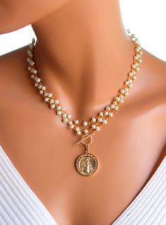 "This a a beautiful triple layer pearl necklace with a large Mary pendant hanging from toggle front. These lovely layers are made of 6mm freshwater pearls on 24k gold-plated brass with a 18k gold filled Mother Mary pendant, measuring 25mm, hanging form the gold filled toggle. This necklace can be worn many ways as shown in photos. Comes in a 50\" length. All my jewelry comes in a cute gift box with jewelry care instructions. If you would like this style necklace made with a gemstone, please send Cheap Gold Necklaces With Large Beads, Gold Double Strand Pearl Necklace For Jewelry Making, Gold Double Strand Pearl Necklace, Gold Multi-strand Pearl Charm Necklace, Gigi 2023, Layer Pearl Necklace, Pearl And Gold Necklace, Necklace Women Gold, Baroque Necklace