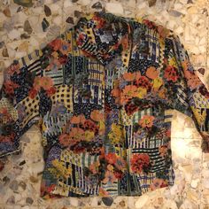 Pretty and chic 1980s Kenzo jeans oversize floral and patchwork blouse. Wonderful print!! Multicolor bouquets of flowers over an abstract grid of patchwork patterns. The fabric is a sheer poly with a wonderful drape. The shape of the blouse is very oversize and slouchy romantic. Sleeve cuffs have elastic and ties to make a bow. Plastic buttons up your front. Label Kenzo jeans size m. Poly fabric. Please hand wash cool, drip dry. Very good vintage condition with no fabric or seeing flaws. Measure Casual Multicolor Blouse With Floral Patchwork, Multicolor Print Patchwork Blouse For Spring, Multicolor Patchwork Blouse For Spring, Fall Floral Patchwork Blouse, Multicolor Floral Patchwork Blouse For Spring, Spring Vintage Blouse With Colorful Pattern, Spring Multicolor Blouse With Floral Patchwork, Spring Floral Patchwork Multicolor Blouse, Spring Floral Patchwork Patterned Blouse