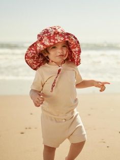 Kid and toddler sun hat in scarlet red floral by Kit & Wilder. The best sun hat that will stay on your toddler's head. This cute kids hat has an adjustable chin-strap and mesh lining to keep your baby's head cool. The perfect accessory for your beach day, family vacation or sunny day in the yard. Protect your baby from sun without sacrificing style for your flower child. We love a good boho and hippie look and this hat is no exception. Shop our whole site for summertime staples for your kids. Kids Head, Floral Hat