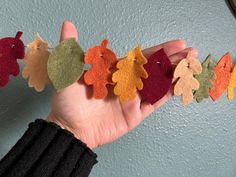 a person holding up some felt leaves