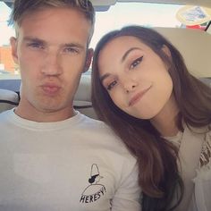 a man and woman are posing for a photo in the back seat of a car