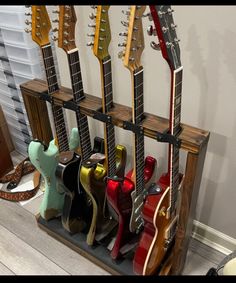 several guitars are lined up in a rack