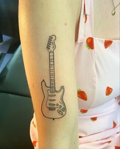 a woman's arm with a guitar tattoo on the left side of her body