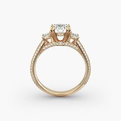 This stunning three stone ring with a cathedral knife edge shank is embelished with gleaming pavé diamonds across the bridge and 3/4 of the ring. The center stone is set in a beautifually crafted double prong basket adorned with a hidden halo. Round brilliant diamonds as side stones to complement this classic and sophisticated design. Yellow Gold Cathedral Engagement Ring, Engagement Ring Hidden Detail, Three Stone Ring With Wedding Band, Cathedral Wedding Ring, Halo Cathedral Engagement Ring, Knife Edge Engagement Ring, Cathedral Engagement Ring, Cathedral Engagement Rings, Cathedral Setting