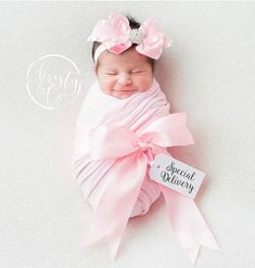 a baby wrapped in pink with a name tag