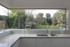 an empty kitchen with a large window overlooking the yard and trees in the back ground