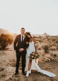 a bride and groom pose for a photo in the desert at their wedding day,