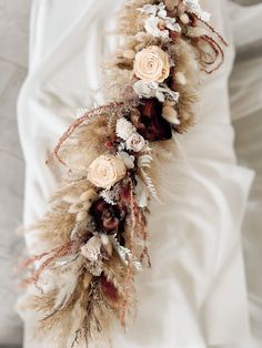 a bridal bouquet with dried flowers and feathers