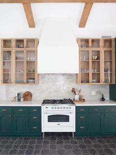 a kitchen with green cabinets and white stove top in front of an instagram sign