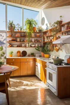 a kitchen filled with lots of pots and pans on the wall next to a stove top oven