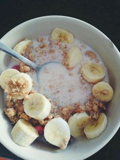 a bowl of oatmeal with banana slices and granola