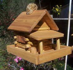 a bird house made out of wood in the yard