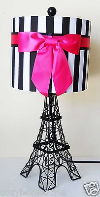 the eiffel tower lamp is decorated with pink ribbon