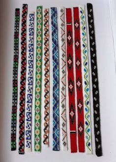 six bracelets are lined up on a white surface, each with different colors and designs