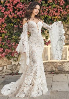 a woman in a white wedding dress standing outside