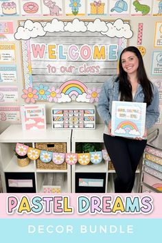 a woman holding up a sign in front of a wall with pastel dreams decorations