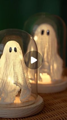 two plastic ghost figurines under a glass dome