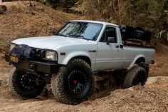 a white truck driving down a dirt road