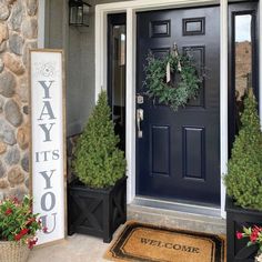 the front door is decorated with wreaths and potted plants