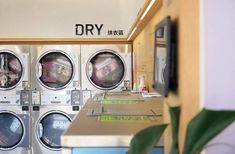 a row of washers sitting next to each other in front of a dryer