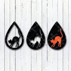 three black and orange tear shaped signs with cats on them