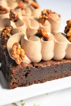 a piece of chocolate cake with walnuts on top and marshmallows in the middle