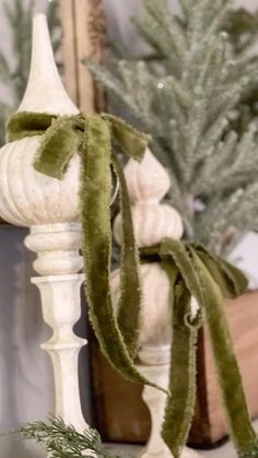 a close up of a christmas decoration on a mantle with pine cones and greenery