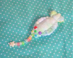 a stuffed animal is laying on a blue polka dot sheet with white dots and green spots