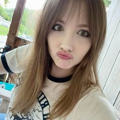 a woman with long brown hair posing for the camera