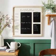 a kitchen with green painted walls and wooden table, potted plants on the counter