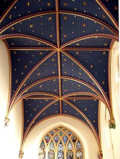 the interior of a church with stained glass windows and star decorations on the vaulted ceiling