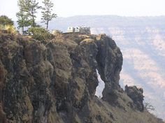 there is a small house on the top of this rock formation in the mountainside