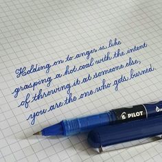 a blue pen sitting on top of a piece of paper next to a writing sample