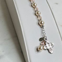 "This lovely First Communion bracelet is sure to be the perfect gift! A beautiful faith-based gift that doubles as a single-decade rosary. Made with ivory pears, vintage rose crystals, and sterling silver. Make it extra special by adding a sterling silver hand-stamped initial. J E W E L R Y ∙ D E T A I L S MATERIAL: Ivory Glass Pearls / Vintage Rose Crystals/ Sterling Silver / Pewter Charm / Silver Plated PENDANT SIZE: Cross: 1/2\" LENGTH: 5 1/2\" + 1/2\" Chain Extender CLASP STYLE: Sterling Sil Elegant Rosary Bracelet With Miraculous Medal Gift, Elegant Rosary Bracelet With Miraculous Medal, Adjustable Rosary Bracelet With Miraculous Medal For First Communion, Adjustable Rosary Bracelet For First Communion And Mother's Day, Personalized Adjustable Rosary Bracelet For Confirmation, Adjustable Rose Gold Rosary As Gift, Communion Gifts Girl, Initial J, Decade Rosary