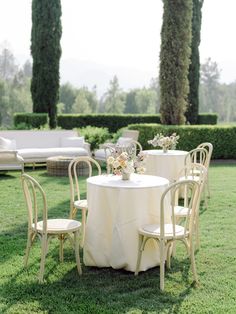 a table and chairs set up in the grass