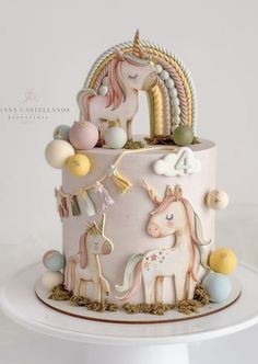 a cake decorated with unicorns and other decorations