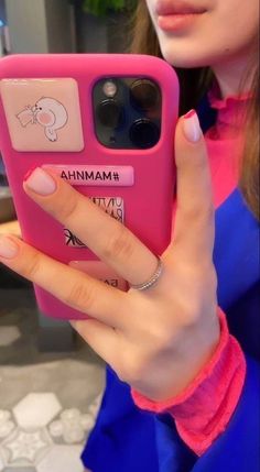 a woman is holding up her pink phone case