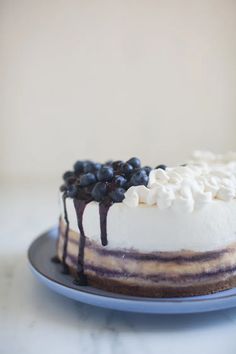 a cake with blueberries and whipped cream drizzled on top