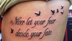 a woman's thigh with a tattoo saying never let your fear decide your fate