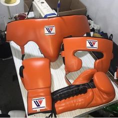 two orange boxing gloves sitting on top of a table