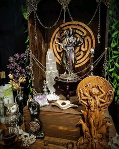 a wooden table topped with an ornate statue next to other decorative items and decor pieces