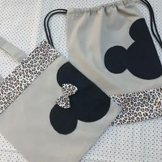 two mickey mouse bags sitting on top of a bed