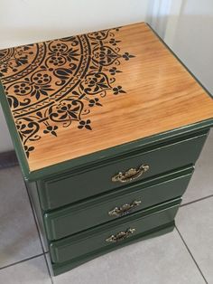 a wooden table with an intricate design painted on it's top and bottom drawer