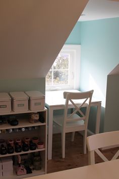 a room with a table, chairs and boxes on the floor in front of a window