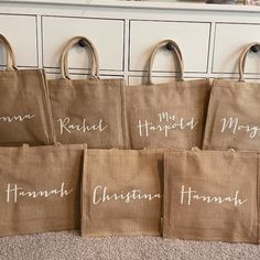 six bags with names are lined up on the floor