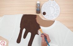 a person is painting a t - shirt with chocolate on it and some paintbrushes